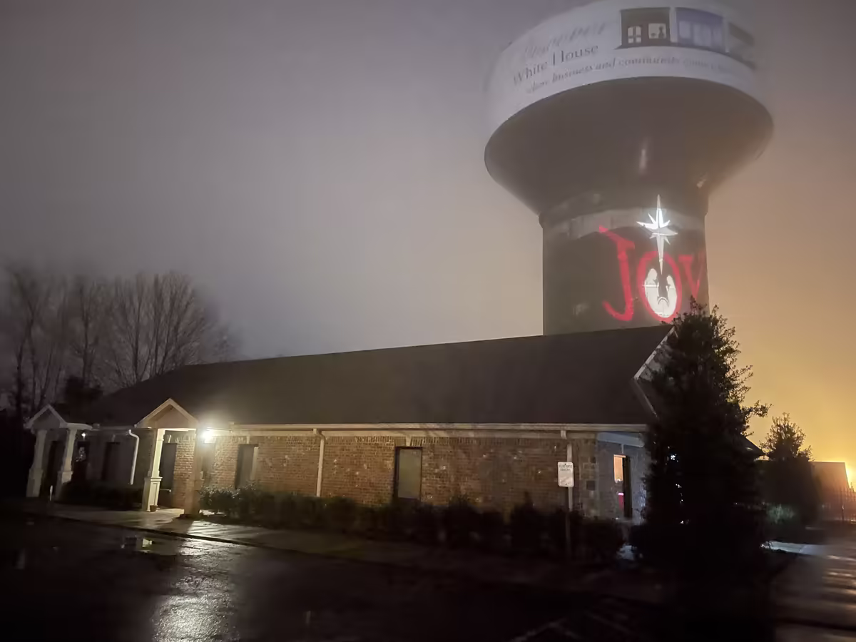Wave It Away building at night with the White House water tower behind it